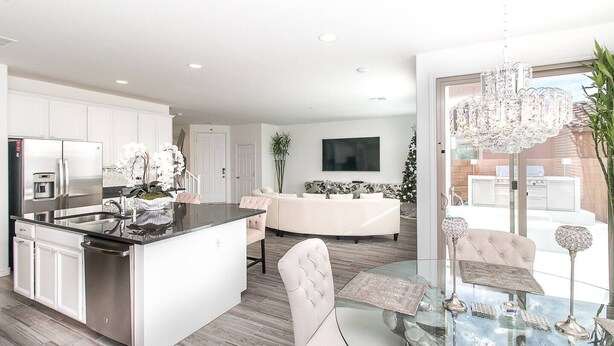 A modern kitchen with a central island, white cabinetry, and a stainless steel refrigerator. - BUTTERFLY Lounge w/2 Masters - 12 min f/the Strip (Las Vegas)