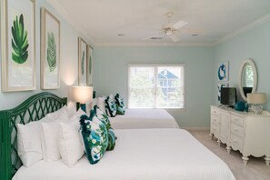 A bedroom with two beds, a dresser, a ceiling fan, and framed botanical prints on the wall. - Beautiful Grand Pavilion -  steps to the beach with Grand Pavilion Pool Access (Isle of Palms)