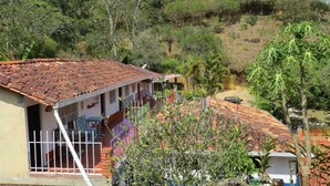 Une maison avec un toit en tuiles, un balcon et une cour clôturée.