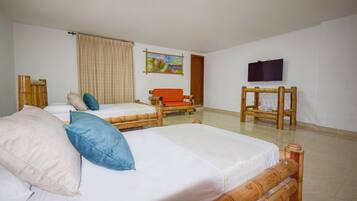 Habitación de hotel con dos camas, un sofá, un televisor y un cuadro en la pared.
