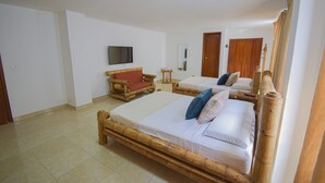 Ein Zimmer mit zwei Betten, einem Fernseher, einem Spiegel und einem hölzernen Stuhl.