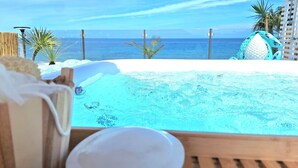 A pool with a view of the ocean, surrounded by palm trees and a wooden deck. - Sunset Villa by the Sea (San Nicola l'Arena)