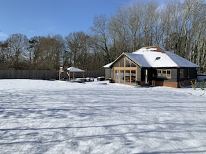 A house with a large glass door and a wooden deck.