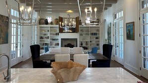 Een ruime woonkamer met een open haard, een eethoek en een grote, open keuken.
