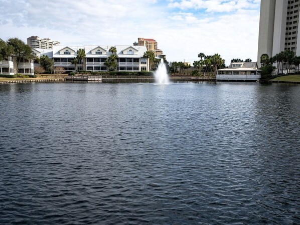 Un hotel frente al agua con una fuente, un muelle y vistas al mar.