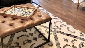 A living room with a leather couch, a coffee table, and a patterned rug.