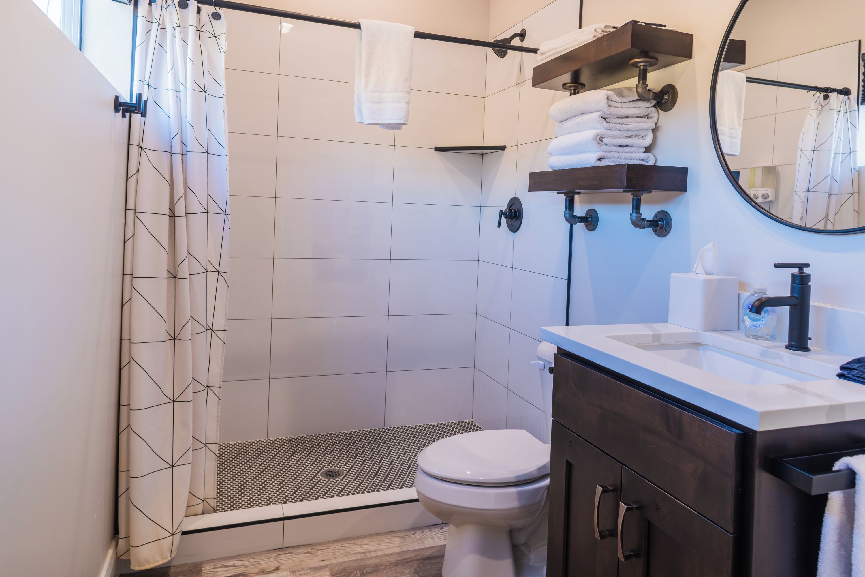 A modern bathroom with a shower, toilet, and sink.
