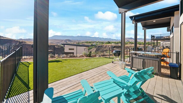A deck with outdoor seating and a view of mountains. - The Dwellings (La Verkin)