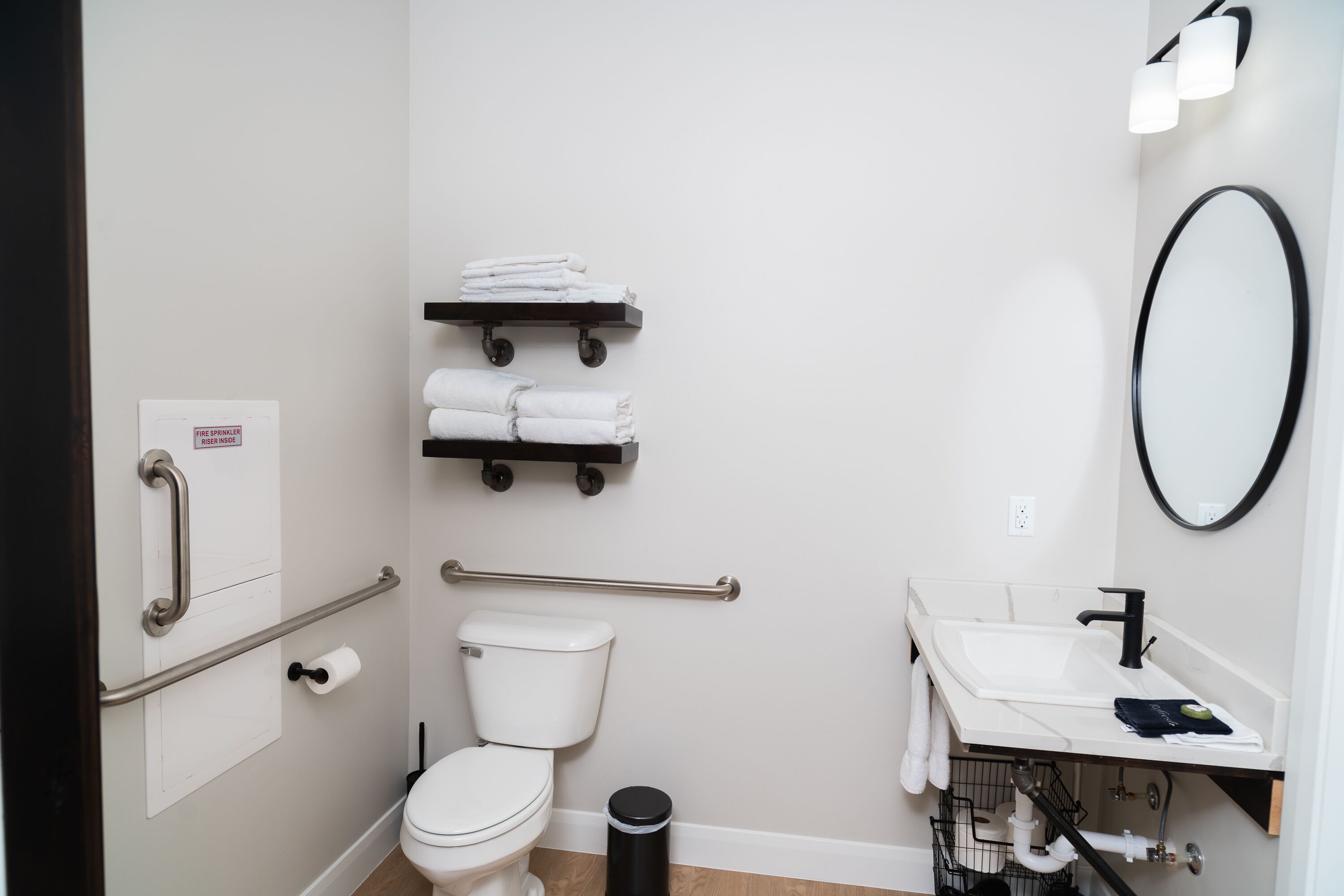Une salle de bain moderne équipée de toilettes, d’un lavabo et de porte-serviettes.