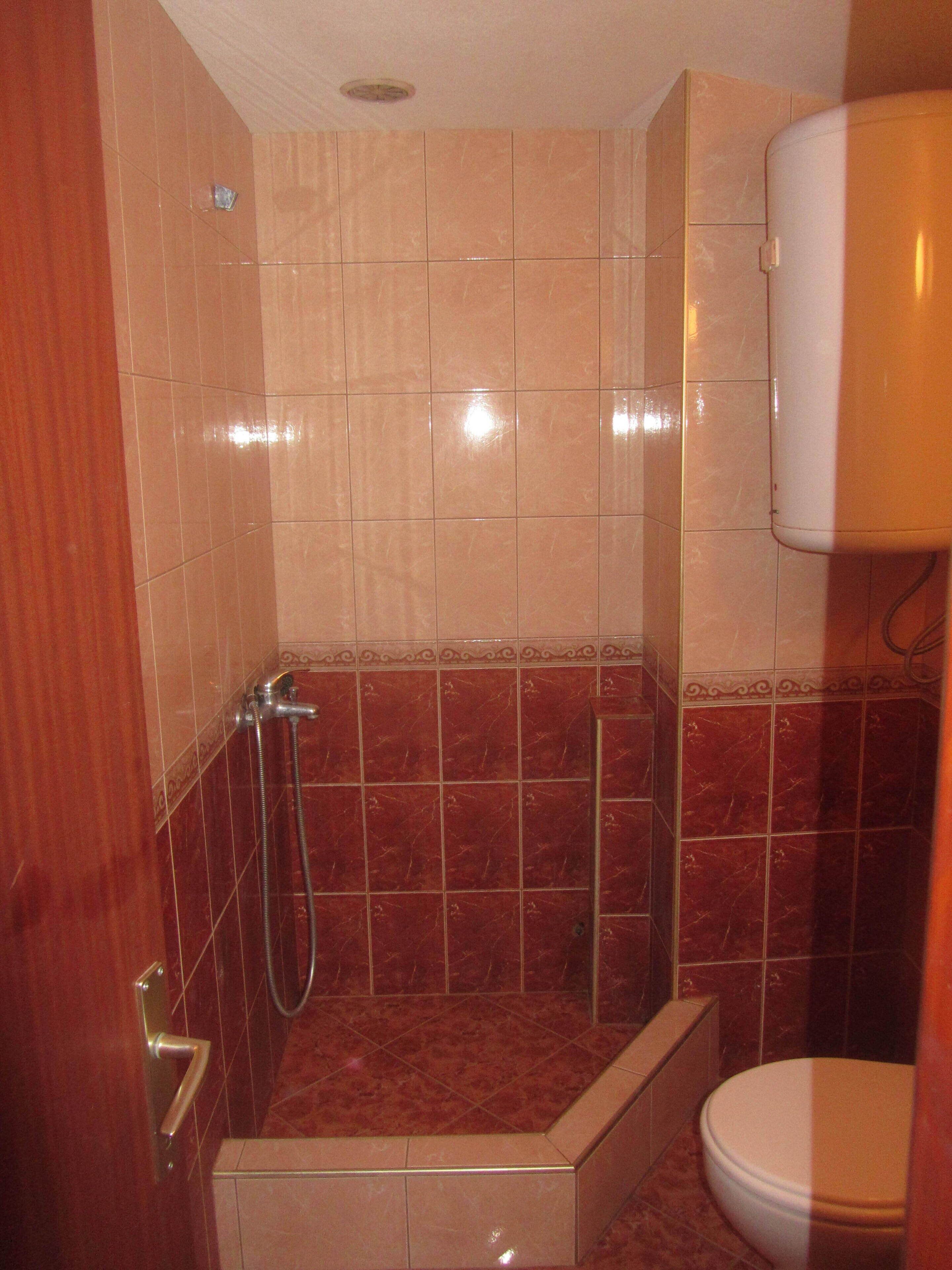 Un baño con ducha, inodoro y lavabo.