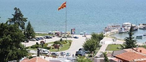 A coastal town with a flag, boats, and a marina.