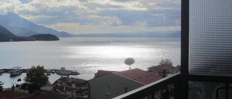 A view of a lake with boats, a small island, and mountains in the background.