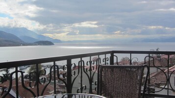 Un balcón con vistas a un lago y montañas.