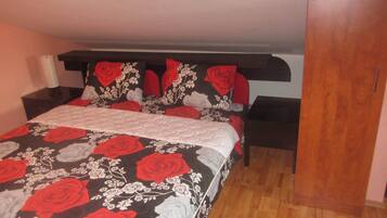 A bedroom with a bed, nightstands, and a wardrobe.