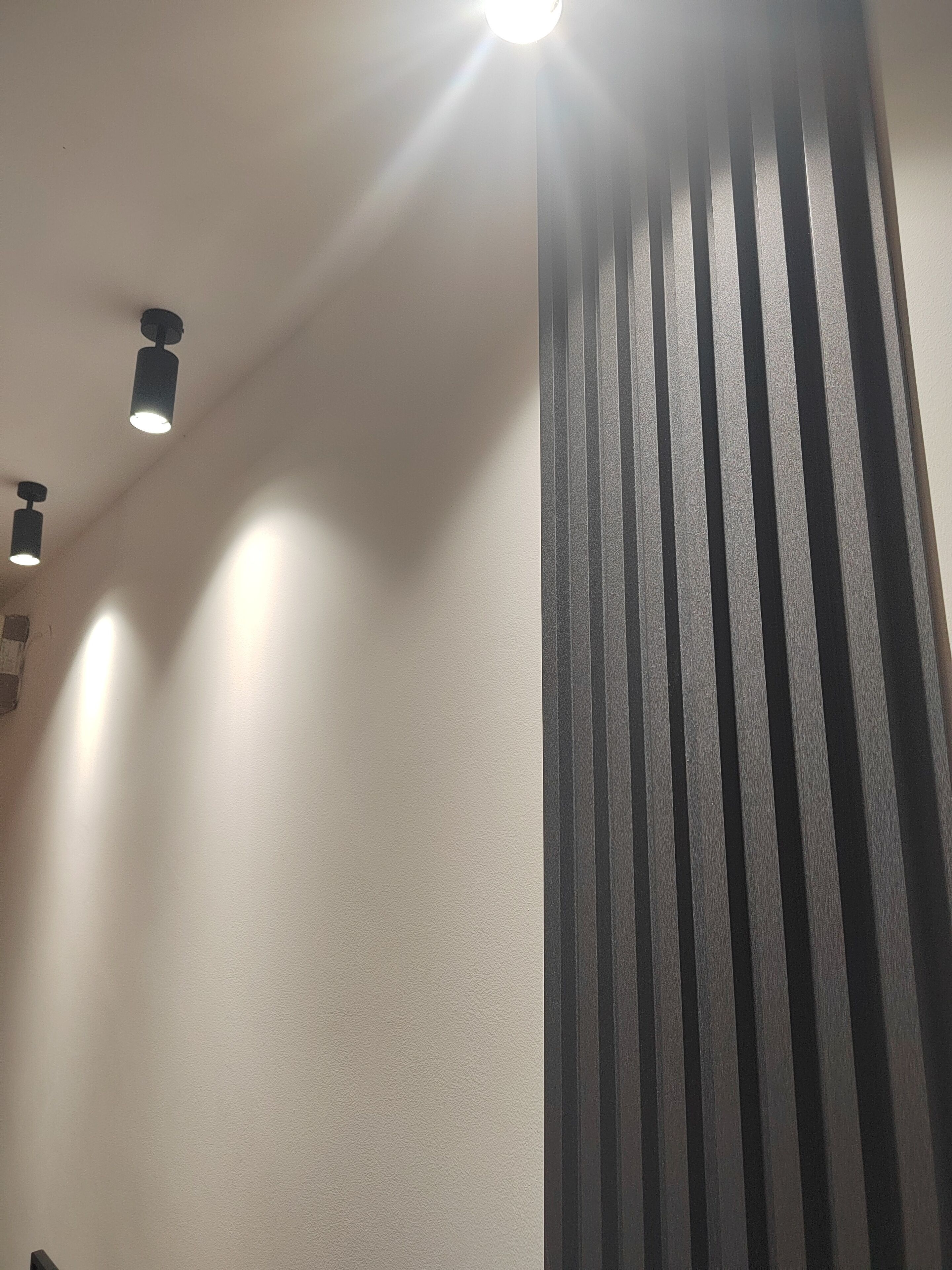 Techo con iluminación empotrada y pared texturizada.