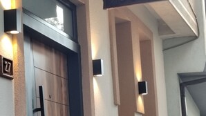 A modern building entrance with a wooden door, numbered room 27, and a sign above reading "Villa Old Town". - Villa Old Town (Ohrid)