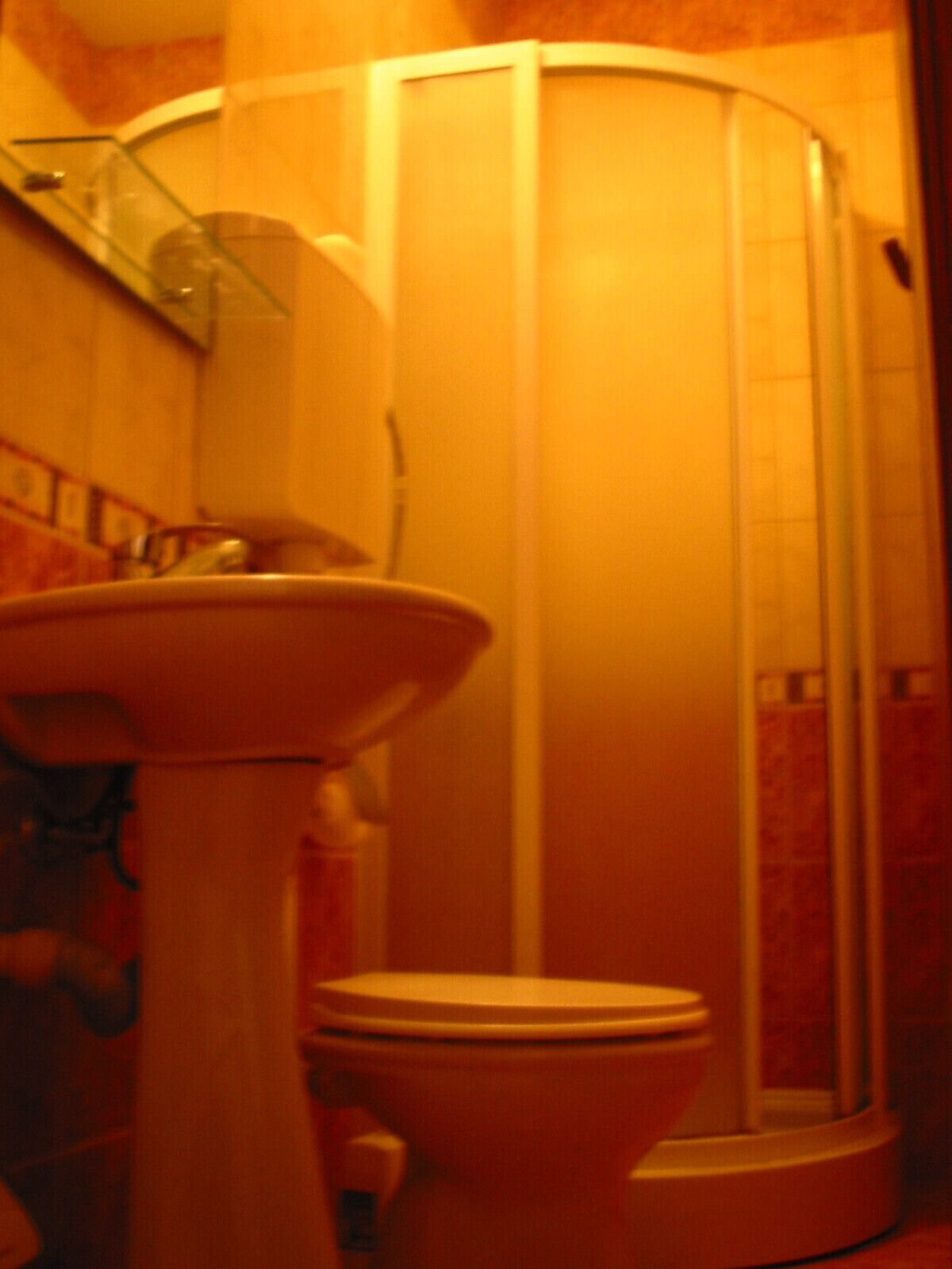 A bathroom with a sink, toilet, and a glass shower enclosure.