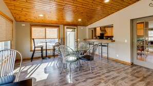 A dining area with a wooden ceiling, a kitchen in the background, and a view through a glass door. - Central Scottsdale Home - Minutes to Old Town (Scottsdale)
