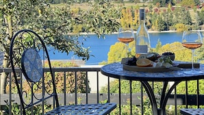 A table with a bottle and glasses, overlooking a lake and mountains. - Stay of Queenstown (Queenstown)