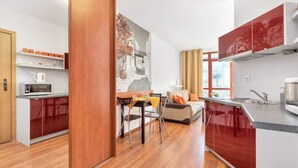Eine moderne Küche mit Essbereich, Holzboden und einem großen Fenster.