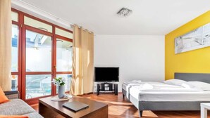 Ein Hotelzimmer mit einem Bett, einem Fernseher, einer Couch und einem Couchtisch.