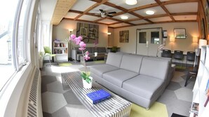 Una sala de estar moderna con un sofá gris, una mesa de centro a rayas y una estantería.