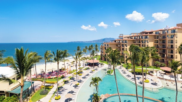 A resort with a pool, palm trees, and a view of the ocean. - Villa del Palmar Flamingos Beach Resort & Spa (Nuevo Nayarit)