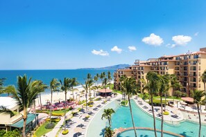 Ein Resort mit Pool, Palmen und Meerblick.