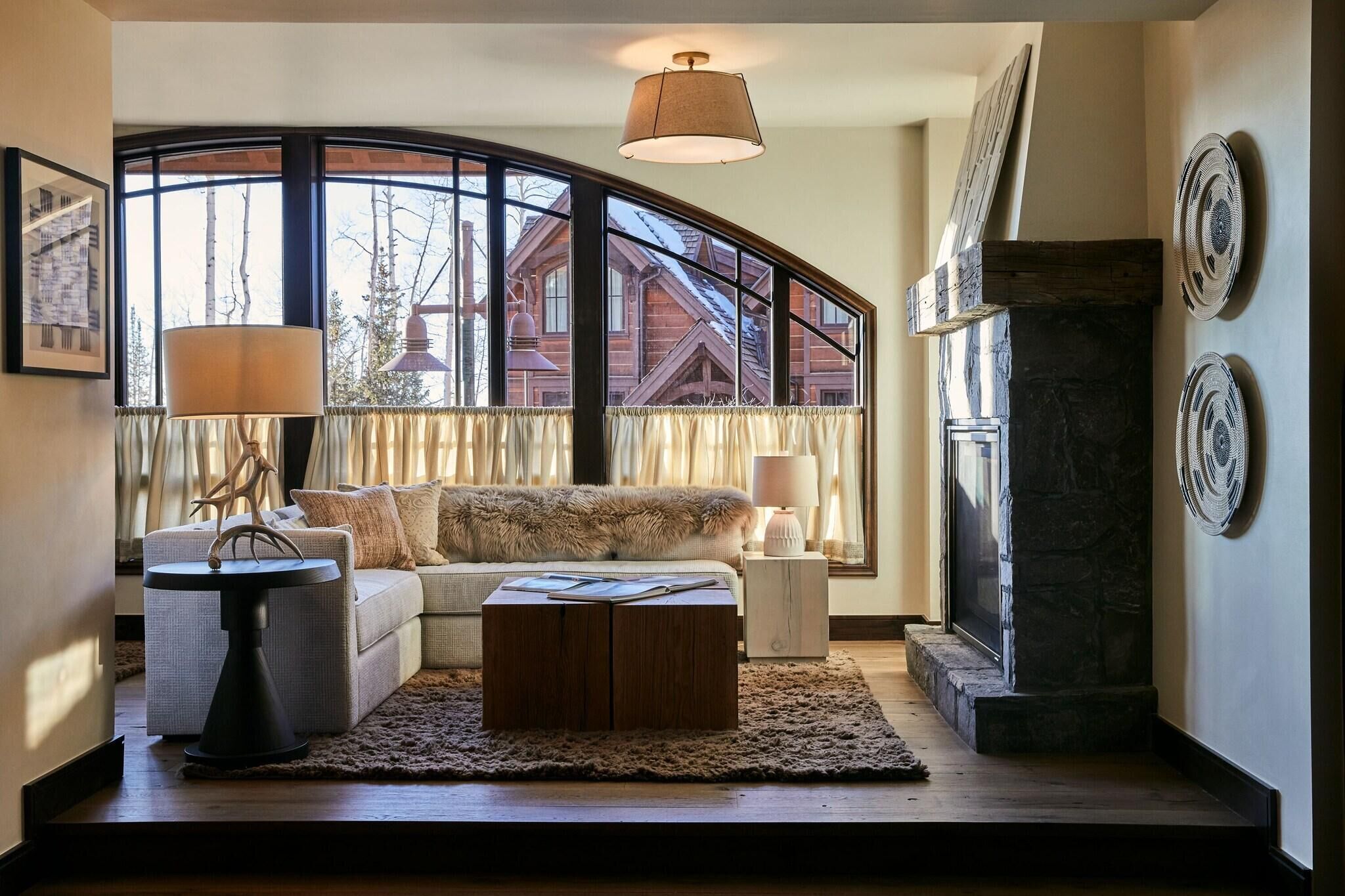 A cozy living room with a sofa, coffee table, and a fireplace.