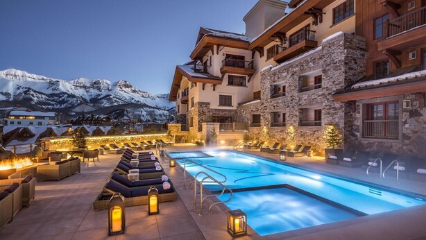 A pool area with lounge chairs and a view of snow-capped mountains. - Madeline Hotel And Residences, Auberge Resorts (Telluride)