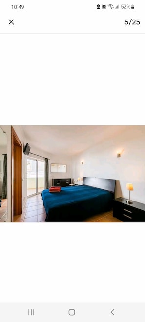 Comfortable bedroom with a large bed, nightstand, and wall-mounted TV.