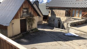 Un bâtiment rustique avec un toit en pente, une porte en bois et un mur en pierre.