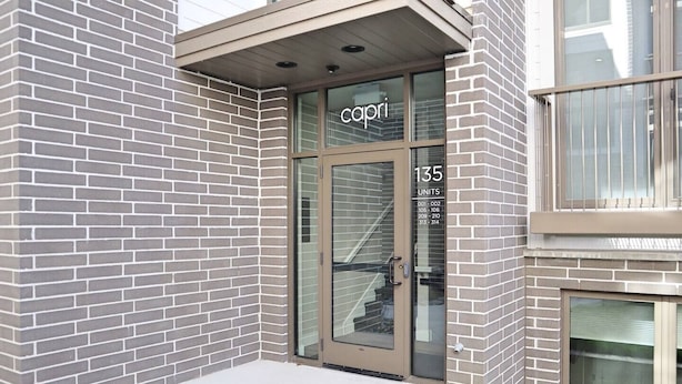A building entrance with a glass door labeled "capri 135" and a sign indicating "UNITS 001-314".