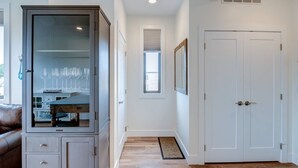 A hallway with a cabinet, a door, and a window. - Capri TC: Charming Downtown TC Oasis (Traverse City)