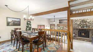 Un coin repas avec une table et des chaises en bois, un tapis à motifs et un lustre.