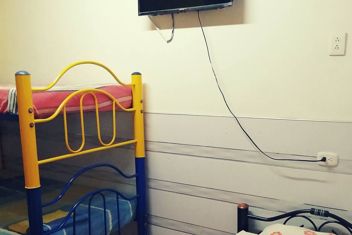 A bunk bed with a television mounted on the wall above it.