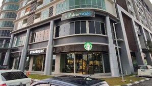 Un edificio de varios pisos con un Starbucks y un letrero de ThinkerTable.