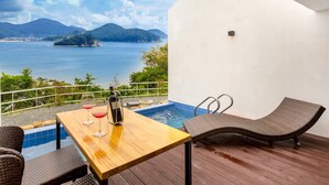 A wooden deck with a pool, a table with two wine glasses and a bottle, and a chair. - Geoje Star Marine Pool Villa Pension - V (Geoje)