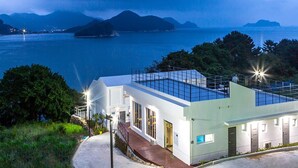 A modern building with a flat roof, large windows, and a pathway leading to the entrance. - Geoje Star Marine Pool Villa Pension - V (Geoje)