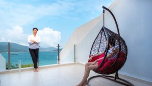 A balcony with a hanging chair and a person standing. - Geoje Star Marine Pool Villa Pension - V (Geoje)