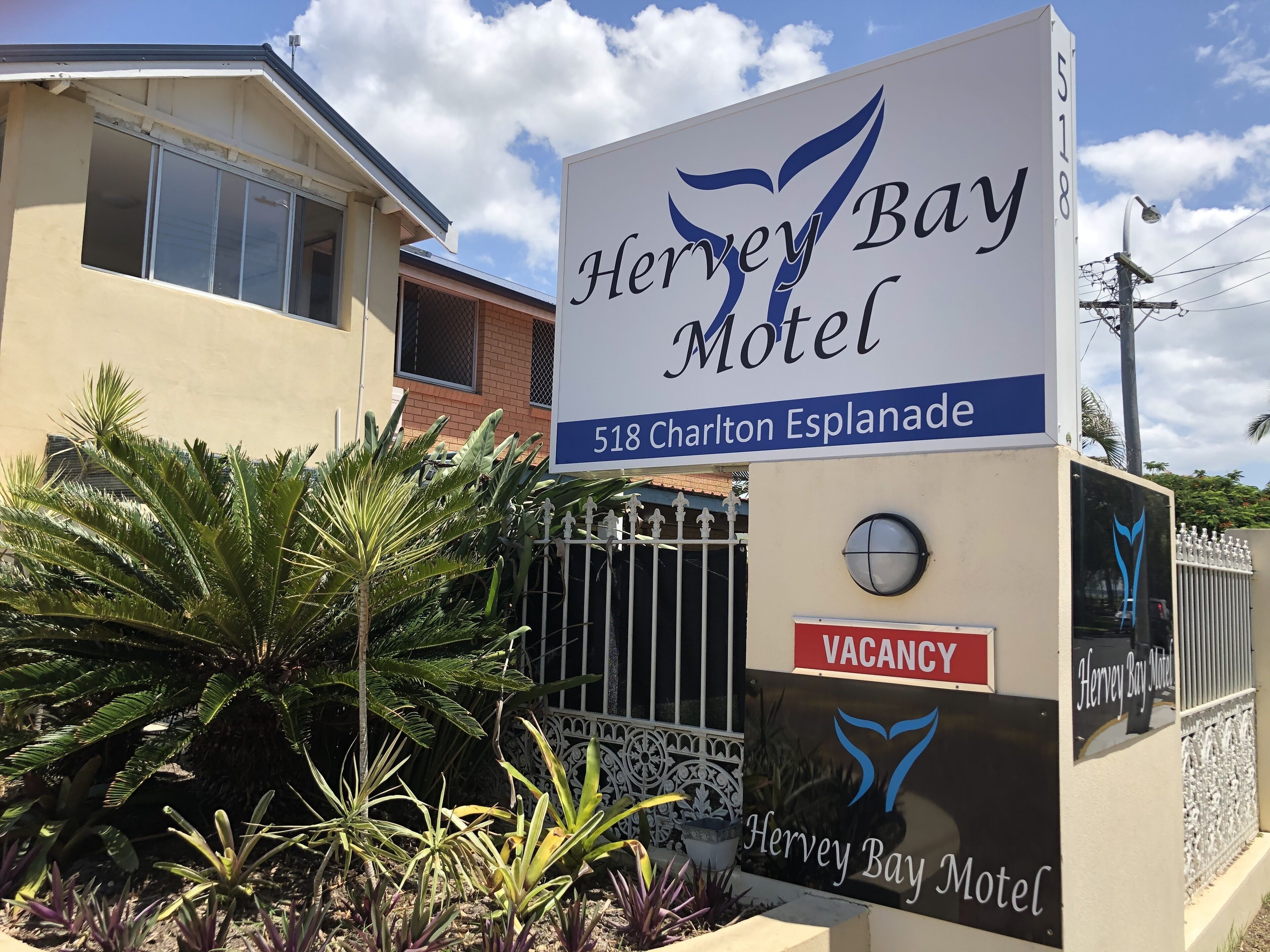 A sign for the Hervey Bay Motel with a 'VACANCY' sign below it.
