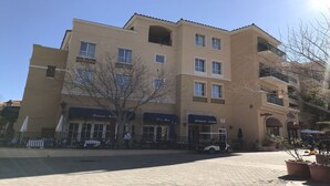 A multi-story building with a ground-level restaurant and a pizzeria. - Lake Las Vegas condo with balcony, lake and golf course view (Henderson)