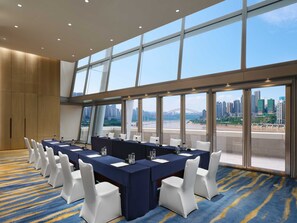 A conference room with a long table, white chairs, and large windows offering a city view. - InterContinental Chongqing Raffles City by IHG (Chongqing)