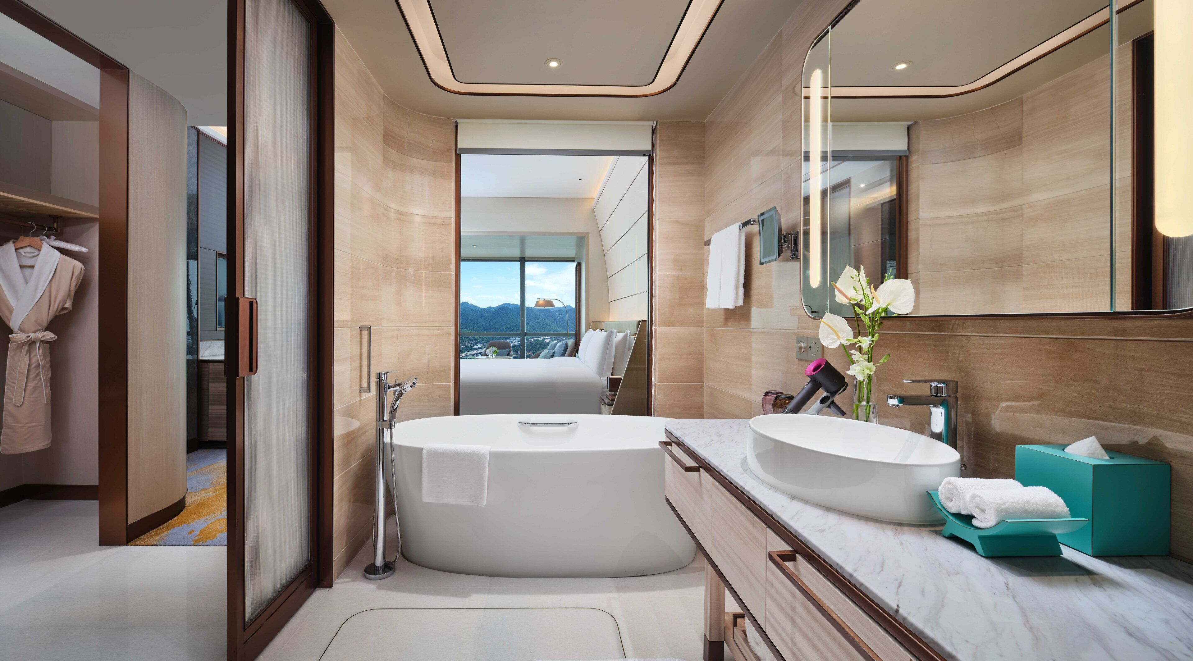 Ein modernes Badezimmer mit einer Badewanne, einem Waschbecken und einem großen Spiegel.