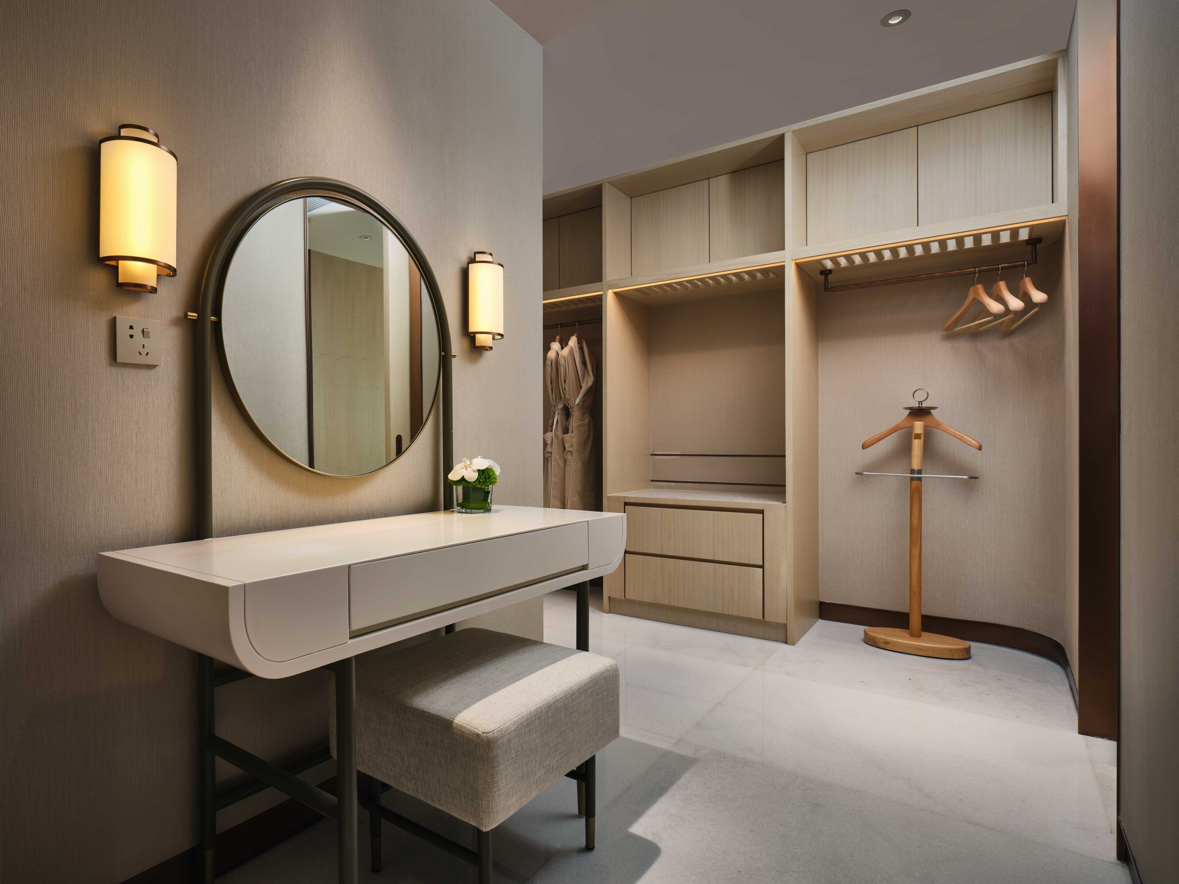A modern bathroom with a vanity, mirror, and built-in storage.