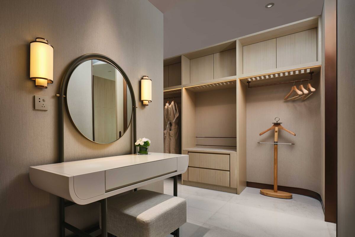 A modern bathroom with a vanity, mirror, and built-in storage.