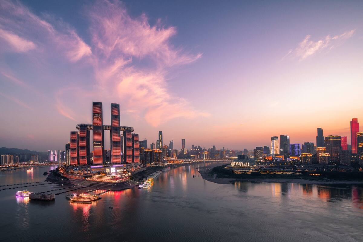 A cityscape with modern skyscrapers, a river, and a bridge.