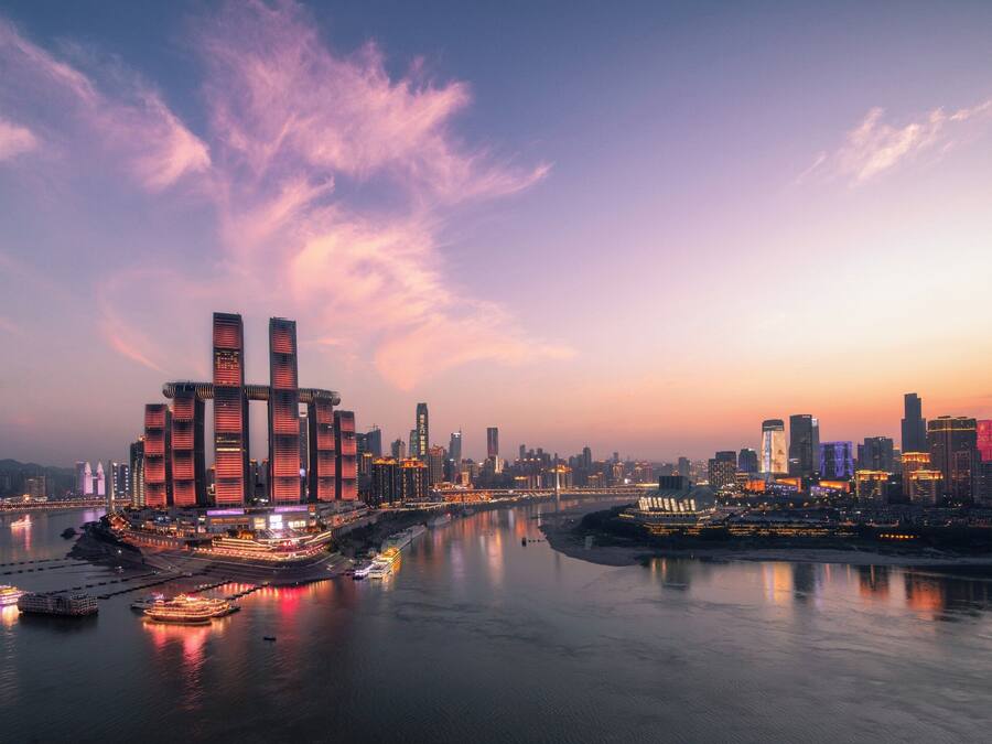 Eine Stadtansicht mit modernen Wolkenkratzern, einem Fluss und einer Brücke.