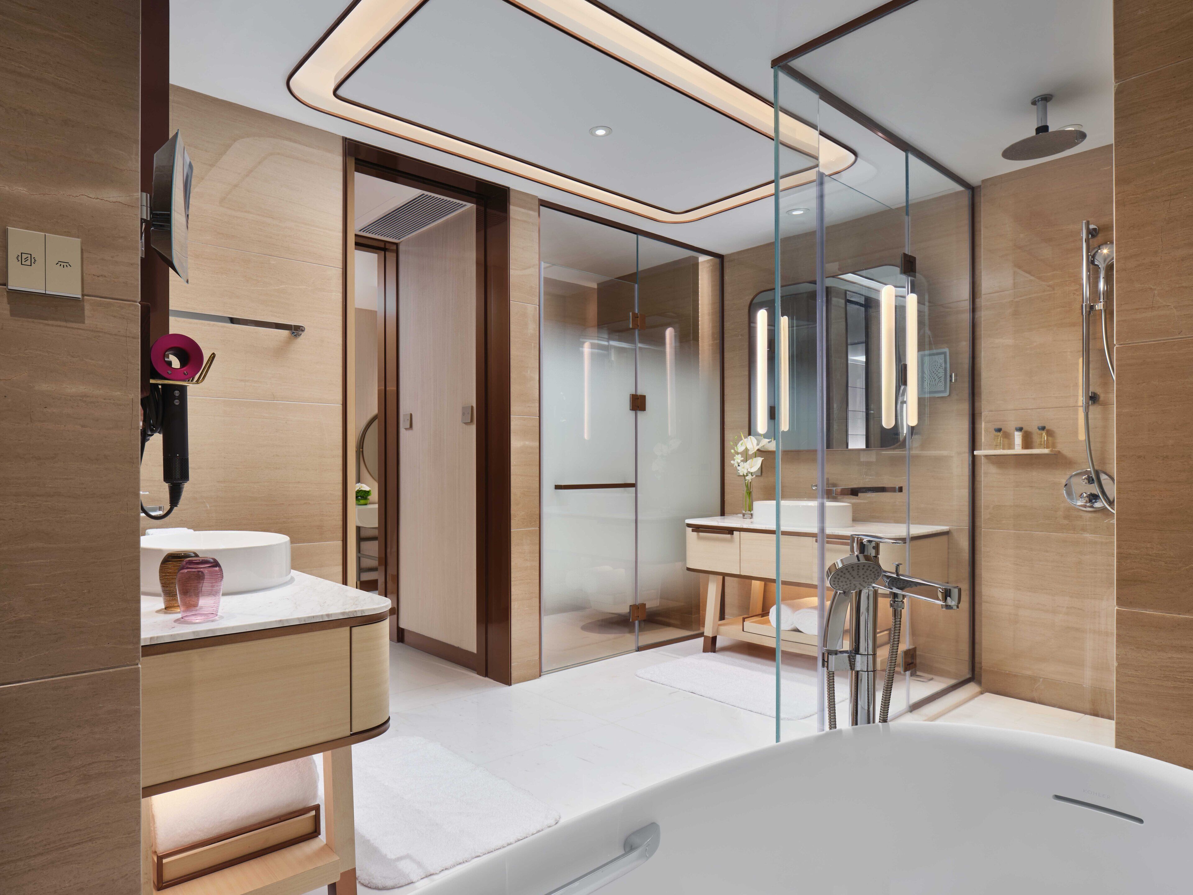 Un baño moderno con un espejo grande, una bañera y una ducha.