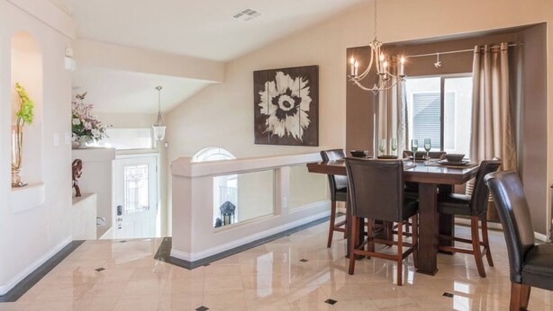A spacious dining area with a high ceiling, a chandelier, and a large window with curtains. - CASA MIA - Las Vegas traditional Luxury (Las Vegas)